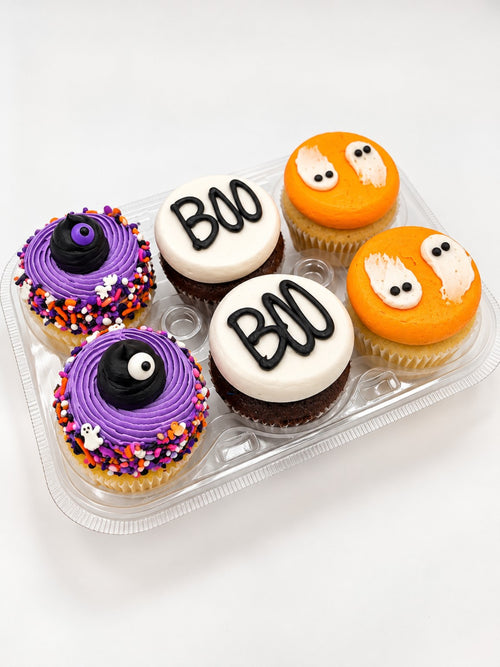 Six Halloween cupcakes with ghost, BOO and purple monster decorations